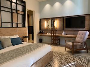 提尔El Boutique Hotel的酒店客房设有一张大床和一张书桌。