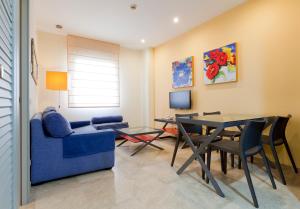 博尔穆霍斯塞维利亚阿加拉菲公寓酒店的客厅配有蓝色的沙发和桌子
