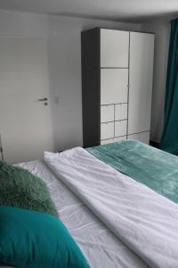 巴林根FeWo Topas Balingen的一间卧室配有白色的床铺和绿色的床单