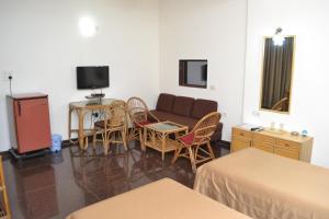 孟买小屋酒店的客厅配有沙发和桌椅