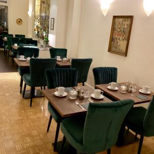 科隆多斯皮腾酒店的用餐室配有木桌和绿色椅子