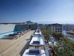 雅典弗莱士酒店的建筑物屋顶上的一排躺椅