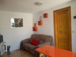 阿尔姆尼卡Casa baja cerca del mar的客厅配有红色枕头的沙发