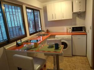 阿尔姆尼卡Casa baja cerca del mar的厨房配有桌子、水槽和洗碗机。