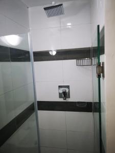 马普托Jardim das Acácias的一间位于客房内的带玻璃淋浴间的浴室