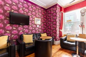 布莱克浦Valentine Lodge Over 25 Couples Only的一间带电视和紫色墙壁的客厅