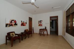 甘地达萨达萨瓦纳度假村 的客厅配有椅子和墙上的绘画作品