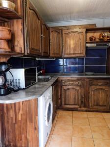 萨拉济Sur la route du Voile的厨房配有木制橱柜和白色洗碗机。