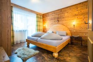 贝旺Alpen Apartments Austria的一间卧室配有一张木墙床