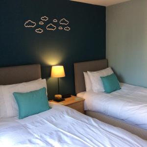 爱丁堡20/5 Timber Bush的两张床位于酒店客房,墙上有云