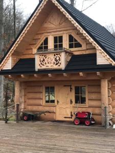 SteningeWalden Cabin的小木屋前面设有红色的停车位