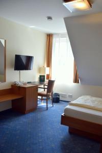 萨尔贝克盖斯特豪弗瓦尔德斯瑞酒店的酒店客房配有书桌和床。