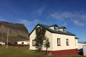 欧拉夫斯维克Experience Beautiful Iceland的一座白房子,后面有山