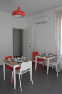 奥列纳Gli olivi的一间设有两张桌子和红色椅子的用餐室