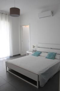 奥列纳Gli olivi的白色卧室配有一张带蓝色枕头的大床