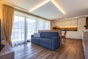 圣马蒂诺-因巴迪亚Chalet Morin的一间带蓝色沙发的客厅和一间厨房
