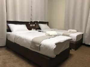 伯利恒Eli Guest House的配有两张床铺的客房内配有白色枕头