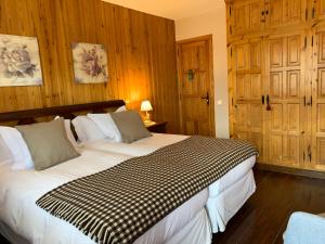 陶尔El Xalet de Taüll Hotel Rural的一间卧室配有一张带木墙的大床