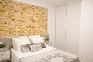 加的斯LUZ DEL FARO的一间卧室设有砖墙和一张床