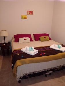 普尔马马尔卡Los Agustinos的一间卧室配有一张大床和毛巾
