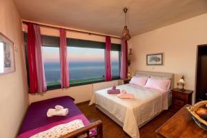 AkhladheríAegean Panorama Apartments的一间卧室设有一张床和一个大窗户