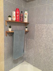 阿尔切纳Apartamento Ahola的浴室设有瓷砖墙和一个带产品架子