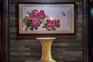 海口海南京山酒店的粉红色花画前面的花瓶