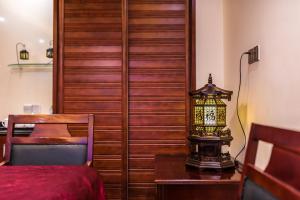 海口海南京山酒店的一间卧室配有一张床和一张带台灯的桌子