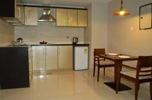 布赖代Yara Suites的厨房配有桌子和白色冰箱。