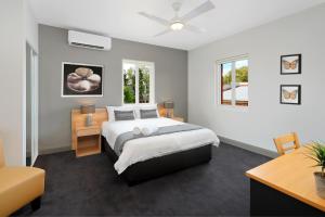 悉尼Kingsgrove Hotel的一间卧室配有一张大床和吊扇
