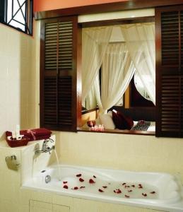 艾尔克如A'Famosa Villas的浴室配有带玫瑰花的浴缸。