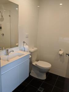 悉尼Kingsgrove Hotel的一间带卫生间、水槽和镜子的浴室