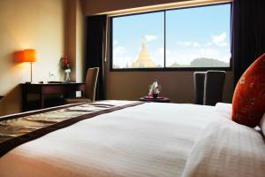 仰光峰会花园景仰光酒店的一间卧室设有一张大床和大窗户