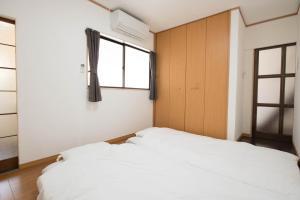 宫岛グローバルリゾート宮島 天神ハウス的一间卧室设有两张白色的床和窗户
