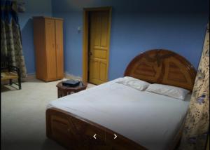 卡拉尔哥特Holiday Inn Guest House的一间卧室配有一张大床和木制床头板