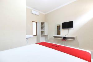 梭罗RedDoorz near Balekambang City Park的白色的客房配有床和电视。