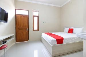 梭罗RedDoorz near Balekambang City Park的白色卧室设有床铺和水槽