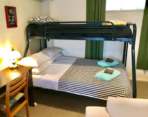 OpuaPerfect Base in the Bay Of Islands的一间卧室配有一张双层床、一张桌子和一把椅子