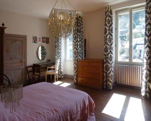 CrespinLes Trois Hiboux的一间卧室配有一张床和一个吊灯