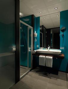 凯尔克拉Fletcher Hotel-Restaurant Parkstad- Zuid Limburg的一间带水槽、淋浴和镜子的浴室
