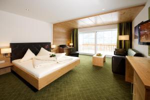 圣加伦基希扎芒斯皮茨山地Spa酒店的酒店客房设有一张床和一个大窗户
