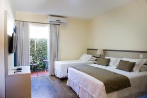 圣若昂-德雷玉兰别墅旅馆的酒店客房设有两张床和电视。
