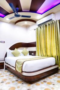Alīpur DuārHotel Bangabhumi的一间设有床的卧室,位于一个黄色窗帘的房间