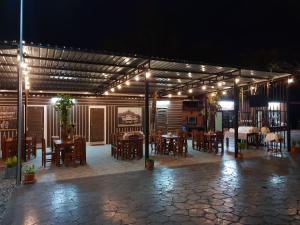 帕府罗麦塞萨恩度假酒店的以及配有桌椅和夜间灯光的天井。