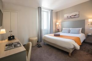 尼斯杜米迪i酒店的酒店客房设有一张大床和一张书桌。