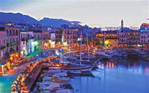 凯里尼亚Kyrenia British Harbour Hotel的一群船在晚上停靠在港口