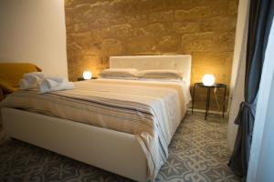 阿格里真托科林毕特拉B&B酒店的卧室配有白色的床铺和石墙