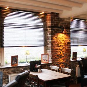 卡斯尔顿Ye Olde Nags Head的一间设有桌子和砖墙的用餐室