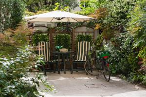 特雷维索Hotel Relais San Nicolò的花园内桌椅和遮阳伞