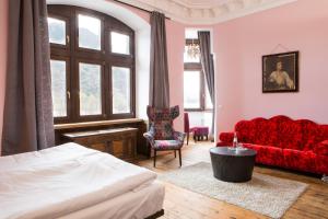科赫姆Hotel Villa Vie Cochem的一间卧室配有一张床和一张红色的沙发